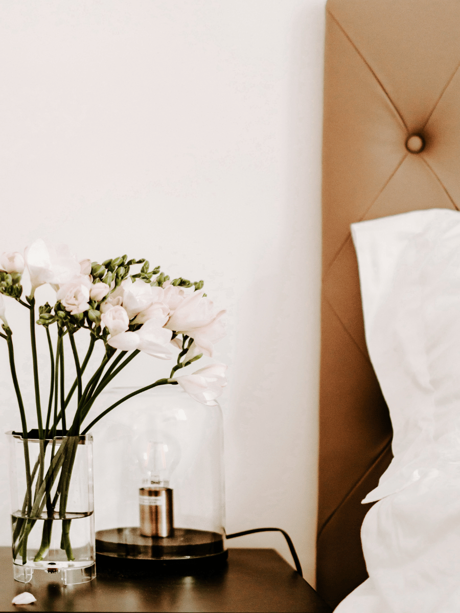 Bedside table with flowers an light